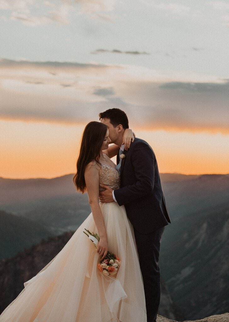 Bride and groom embrace as the sun sets at Yosemite.