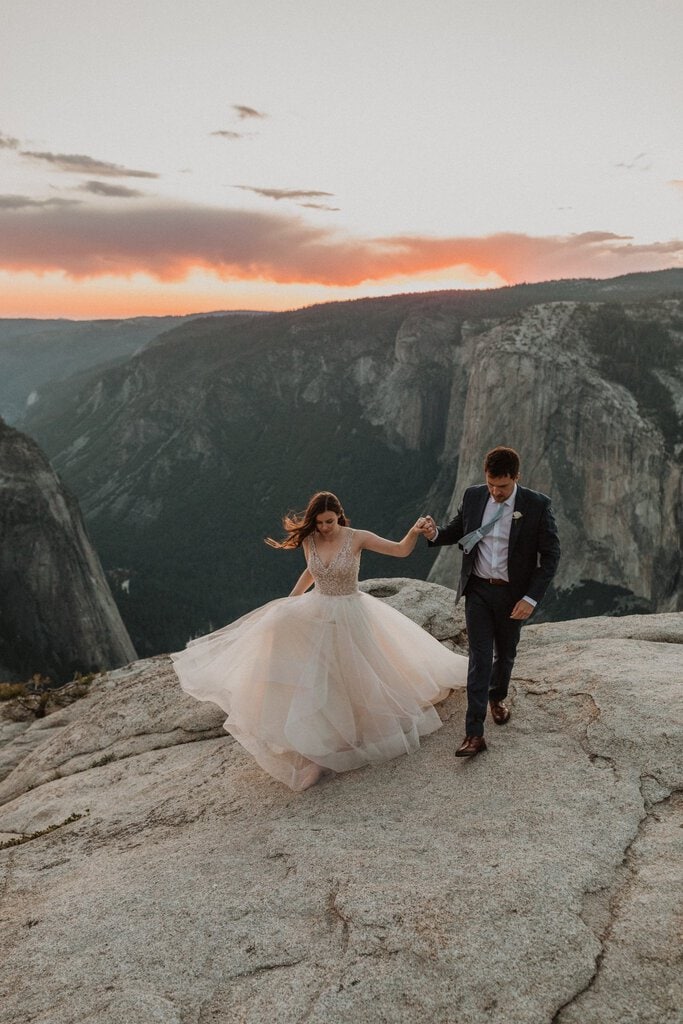 Newlyweds walks on mountain.