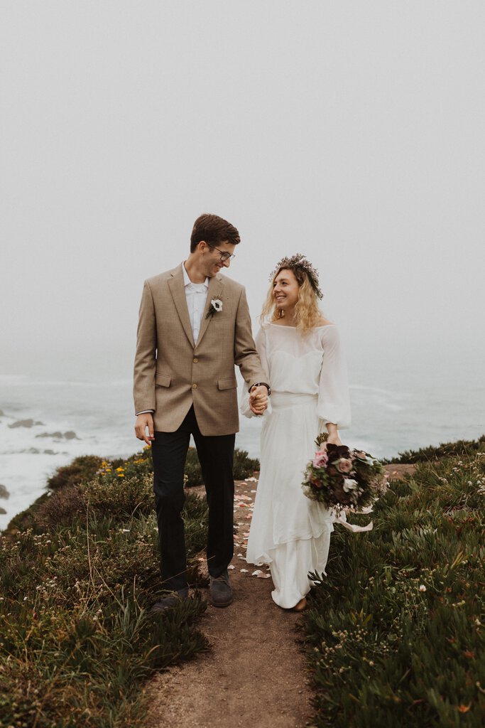 bride and groom walk by the coast in California.