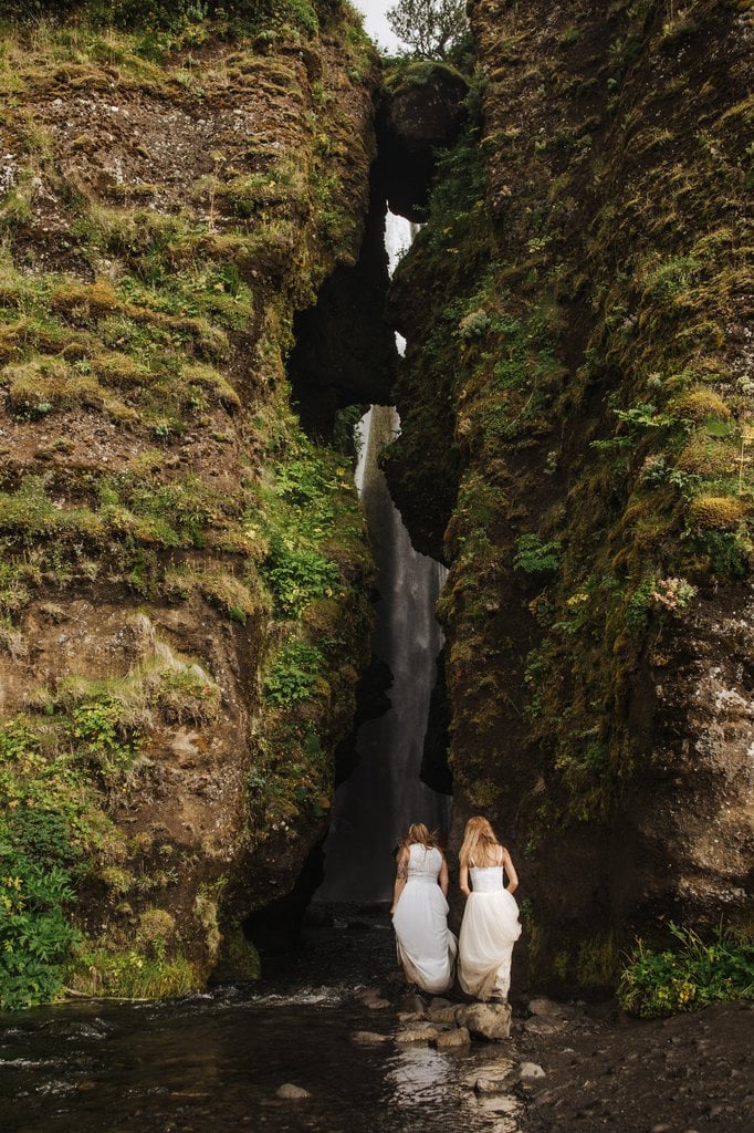 Brides hiking at Seljalandsfoss Cave in Iceland.
