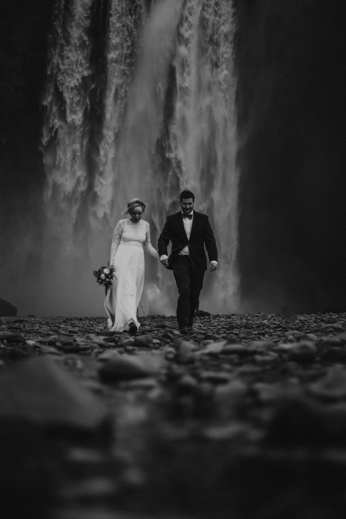 couple walks towards cave in Iceland.