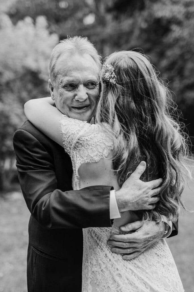 Bride's father hugging his daughter.