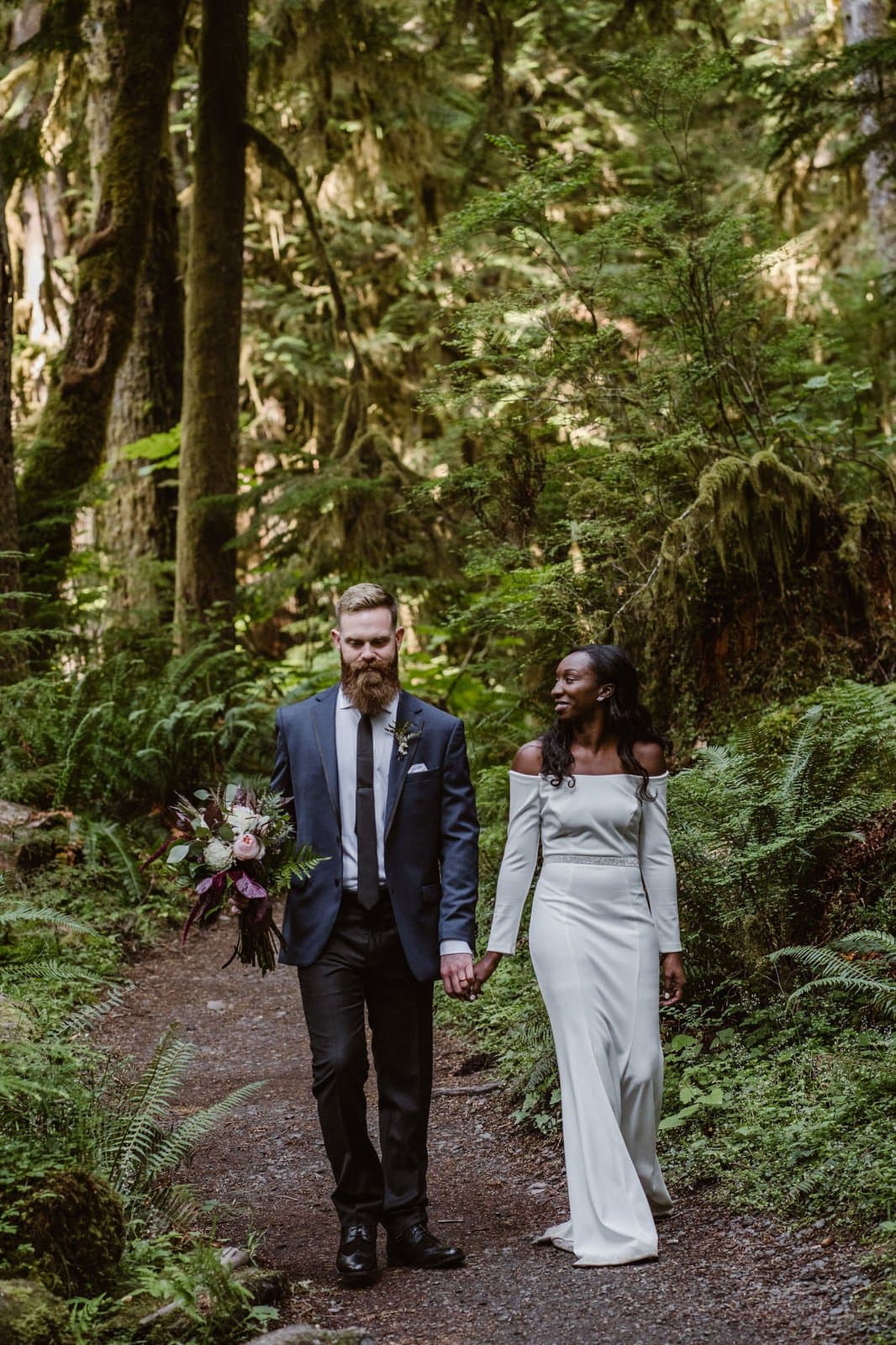 Bride and groom walking through Olympic National Park.