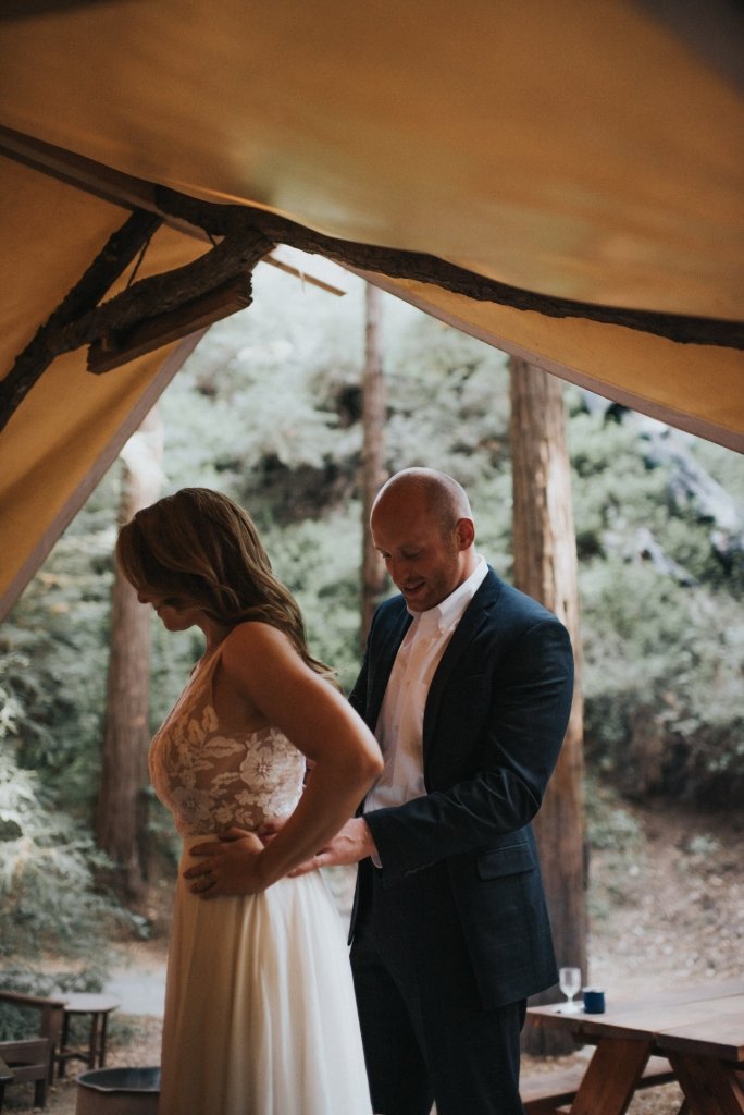 groom helping bride in wedding dress.